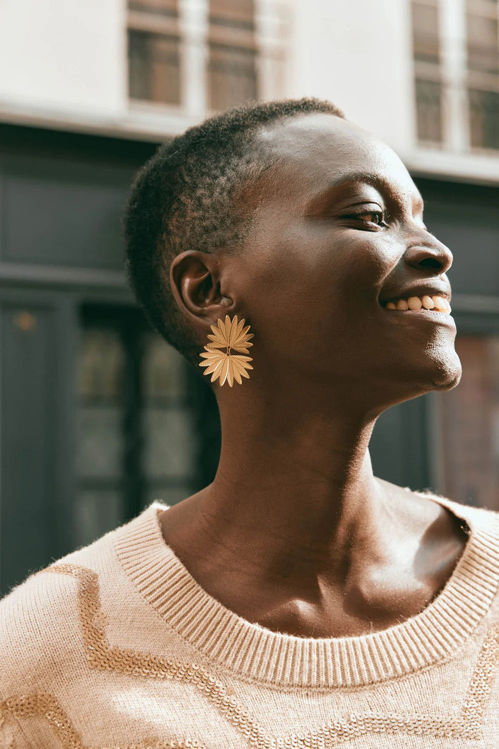 A model wearing the Laax Fan Earring in colour Gold (Metallics), from the front, showing the whole outfit