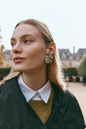 A model wearing the Aman Fan Earring in colour Silver (Metallics), from the front, showing the whole outfit
