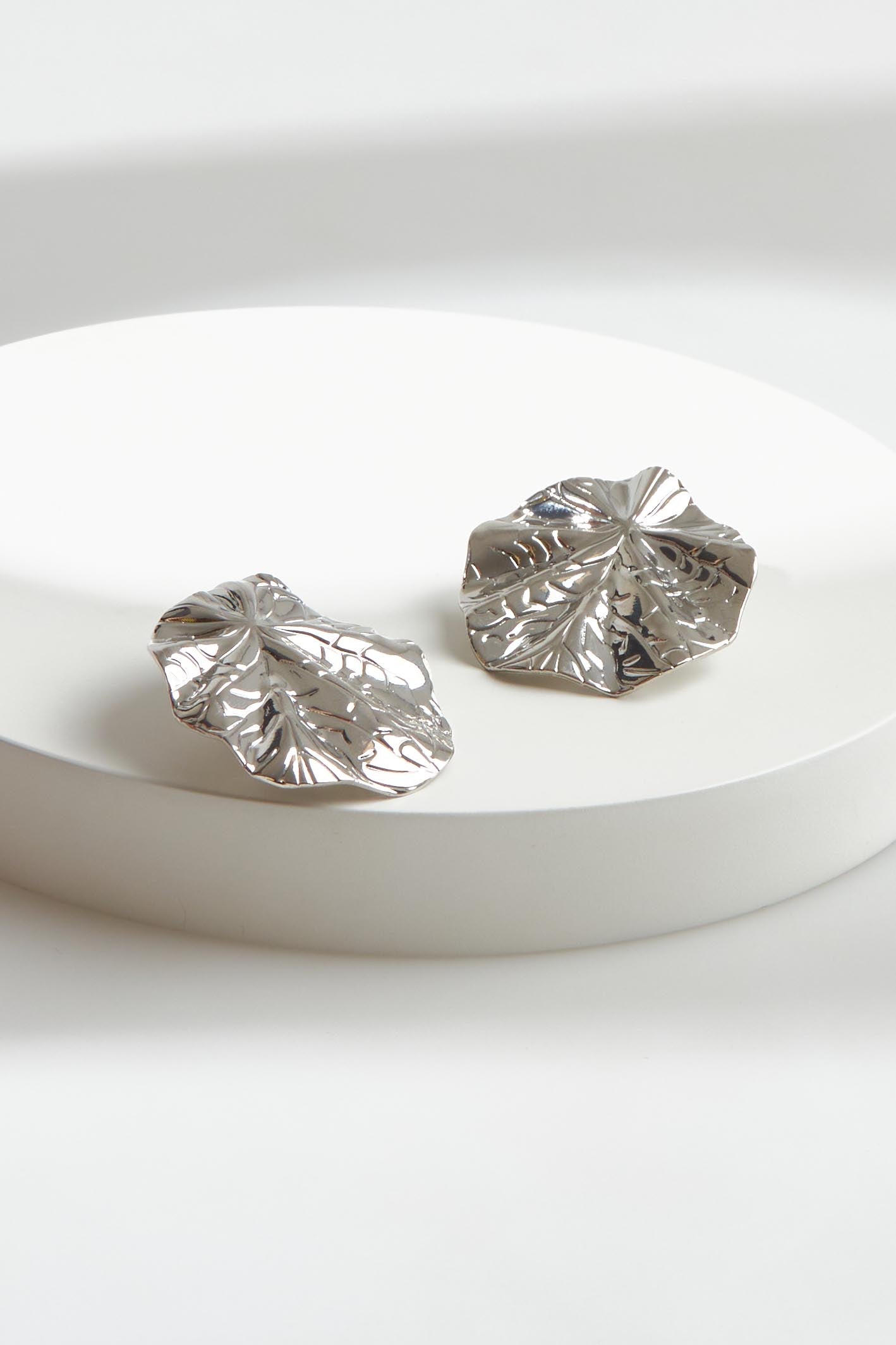 A model wearing the Aman Fan Earring in colour Silver (Metallics), from the front, showing the whole outfit