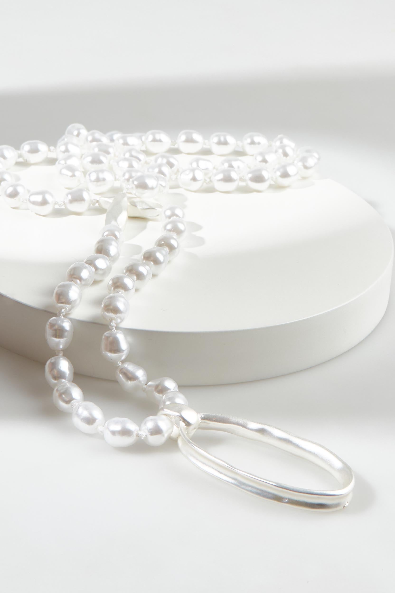 A model wearing the Laax Longline Pearl Necklace in colour Silver (Metallics), from the front, showing the whole outfit