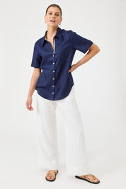A model wearing the Studio Linen Short Sleeve Shirt in colour Navy (Blue), from the front, showing the whole outfit