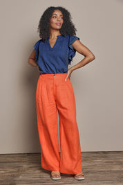Model Ziara wearing size S of the Miranar Linen Palazzo Pant in colour Coral (Red), from the front, showing the whole outfit