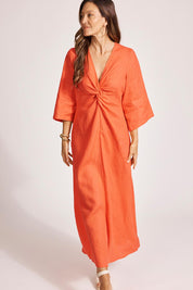 A model wearing the Miramar Twist Linen Maxi Dress in colour Coral (Red), from the front, showing the whole outfit