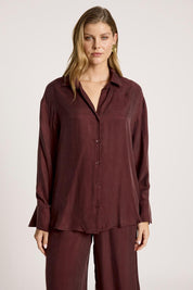 A model wearing the Calista Shirt in colour Mahogany (Red), from the front, cropped image