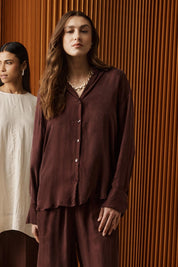 A model wearing the Calista Shirt in colour Mahogany (Red), from the front, showing the whole outfit