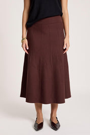 A model wearing the Zala Knit Skirt in colour Mahogany (Red), from the front, cropped image
