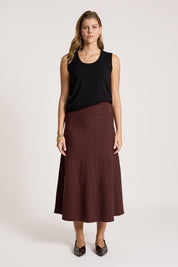 A model wearing the Zala Knit Skirt in colour Mahogany (Red), from the front, showing the whole outfit
