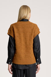 A model wearing the Orin Knit Vest in colour Caramel, from the back