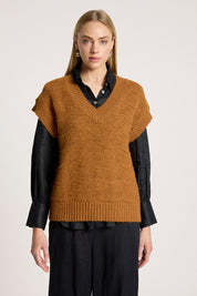 A model wearing the Orin Knit Vest in colour Caramel, from the front, cropped image