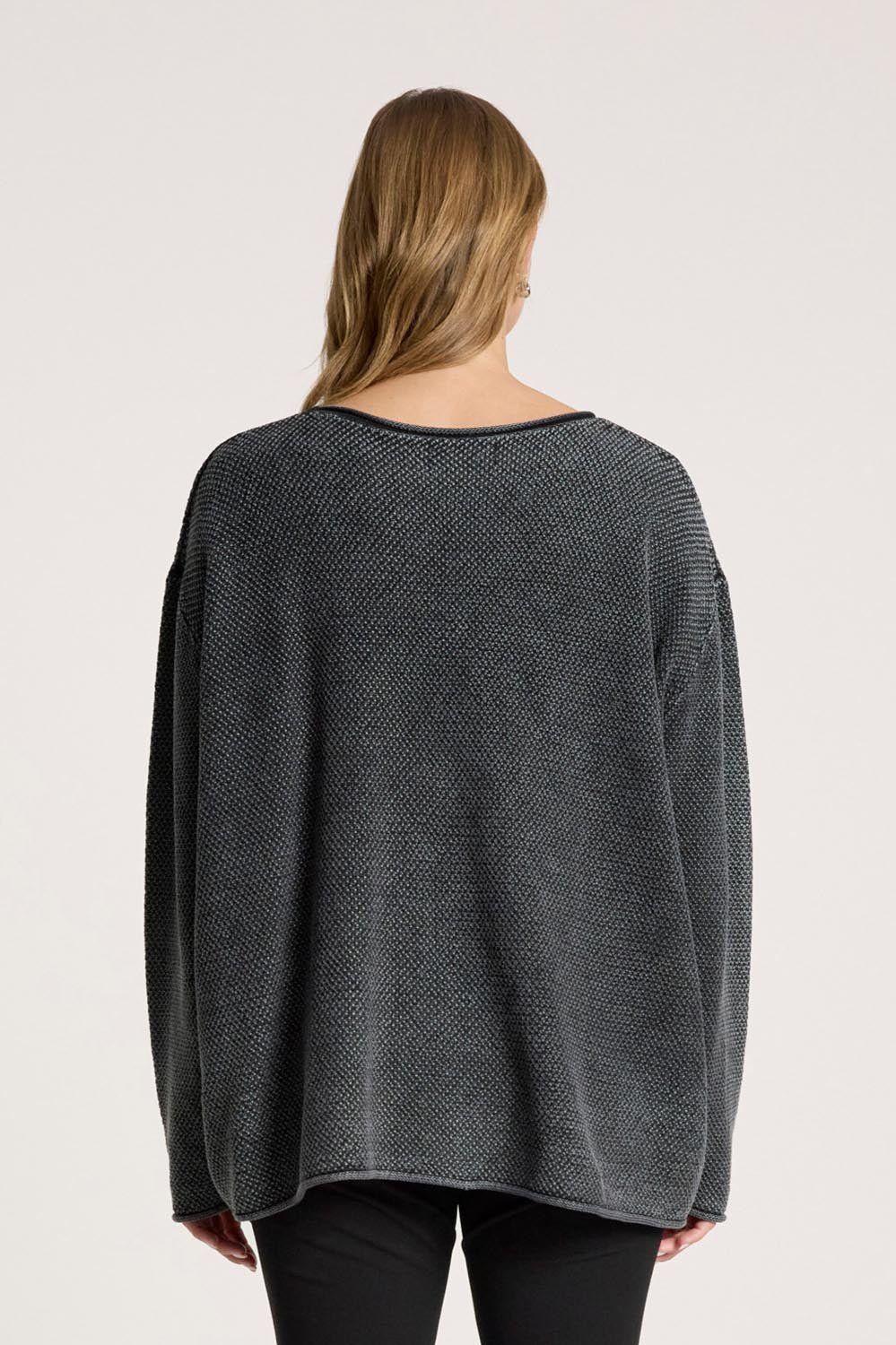 A model wearing the Apache Jumper in colour Black (Black), from the back