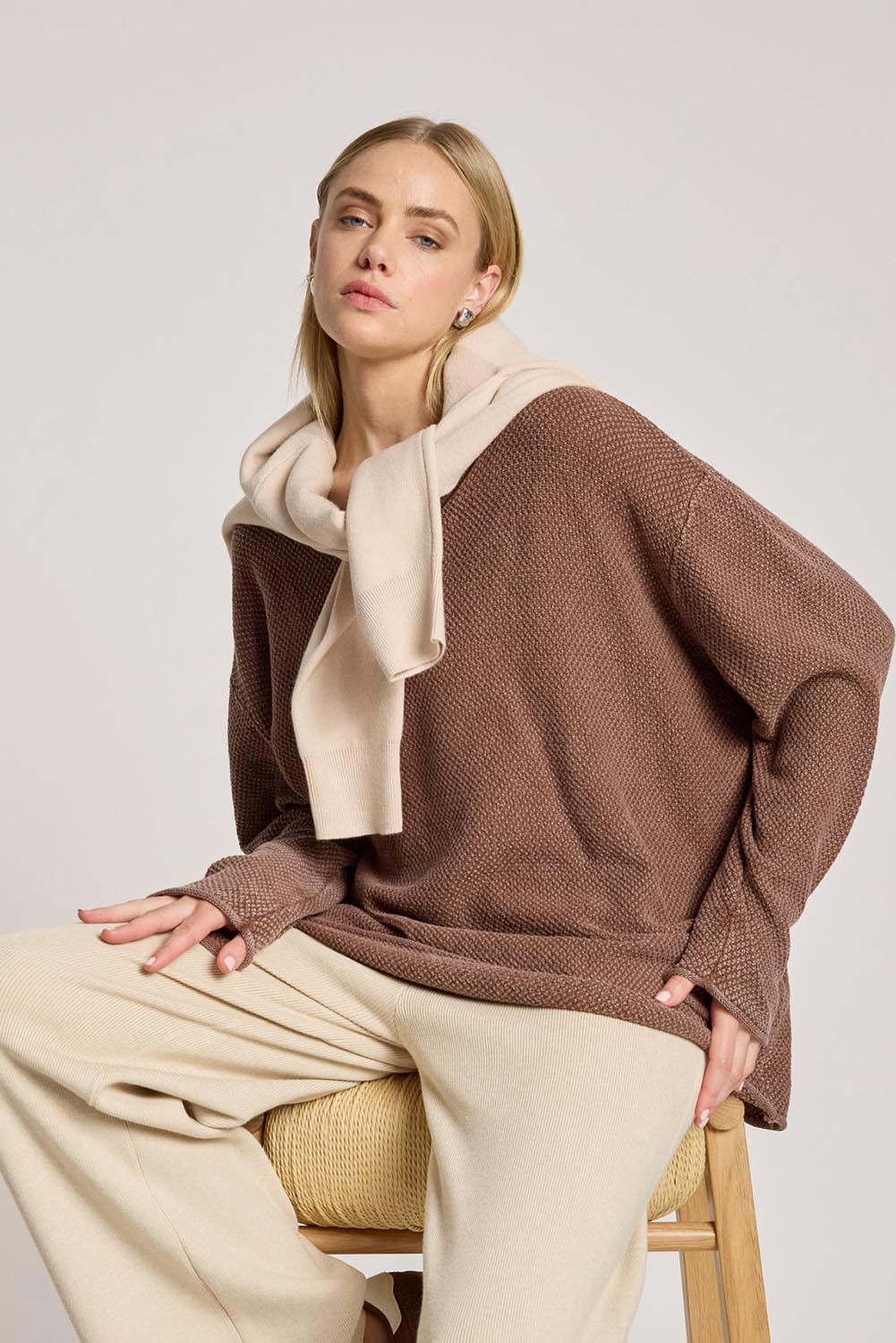 A model wearing the Apache Jumper in colour Coco, from the front, cropped image
