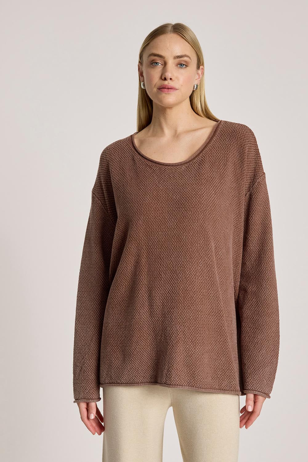 A model wearing the Apache Jumper in colour Coco, from the front, cropped image