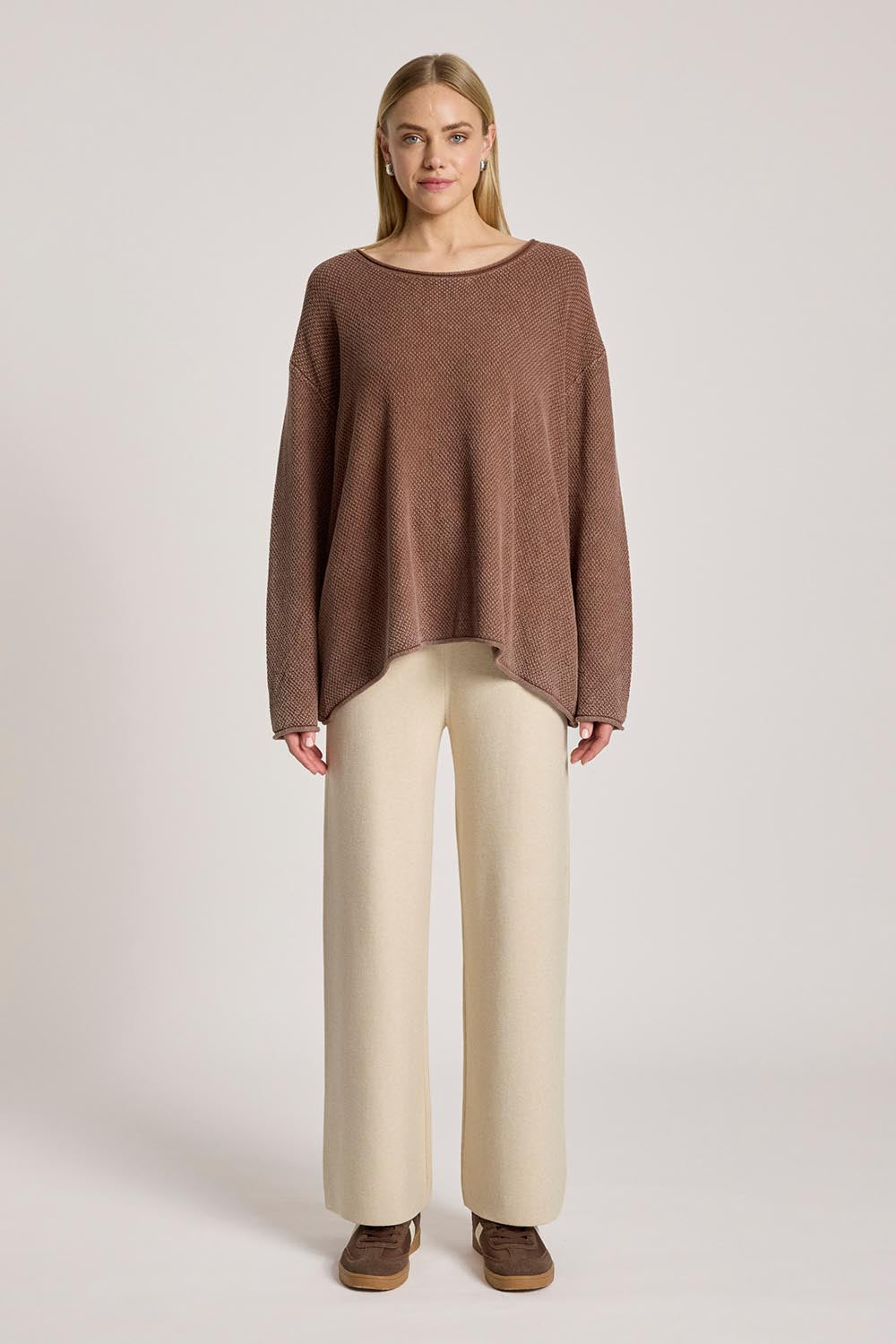 A model wearing the Apache Jumper in colour Coco, from the front, showing the whole outfit