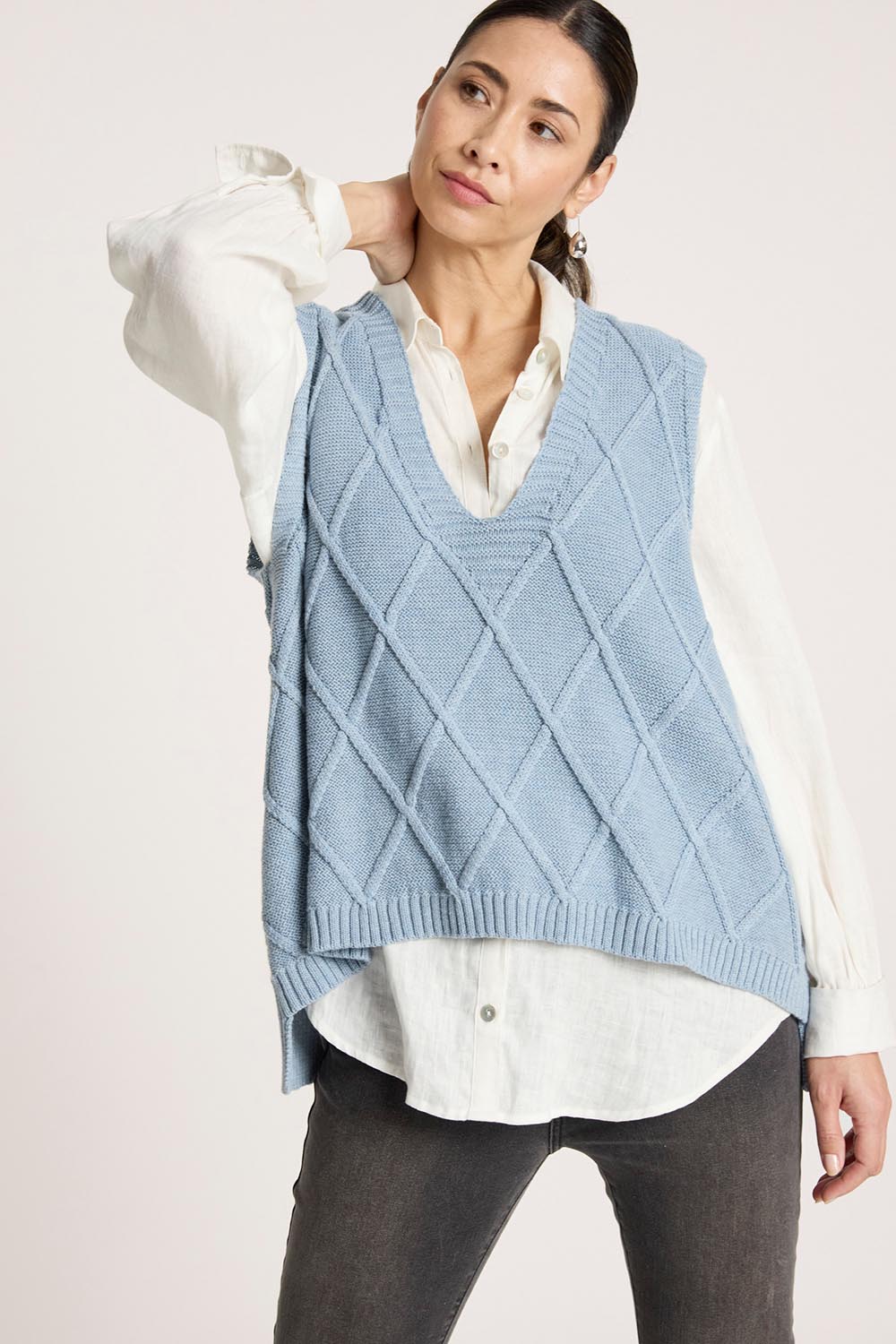 A model wearing the Liora Knit Vest in colour Lake (Blue), from the front, cropped image