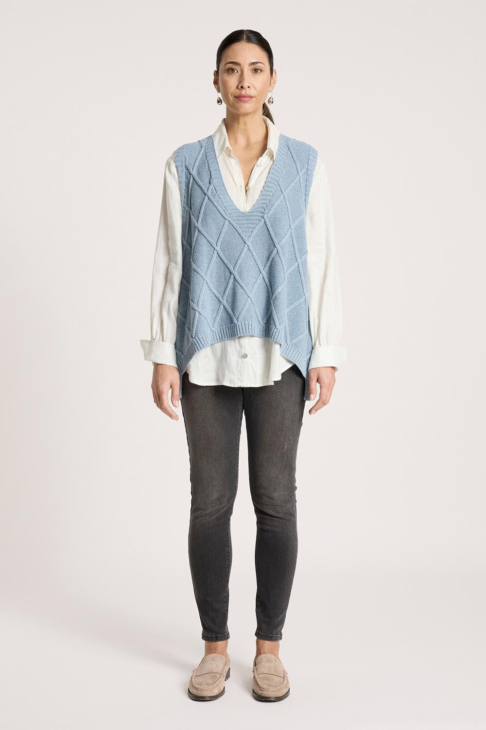 A model wearing the Liora Knit Vest in colour Lake (Blue), from the front, showing the whole outfit
