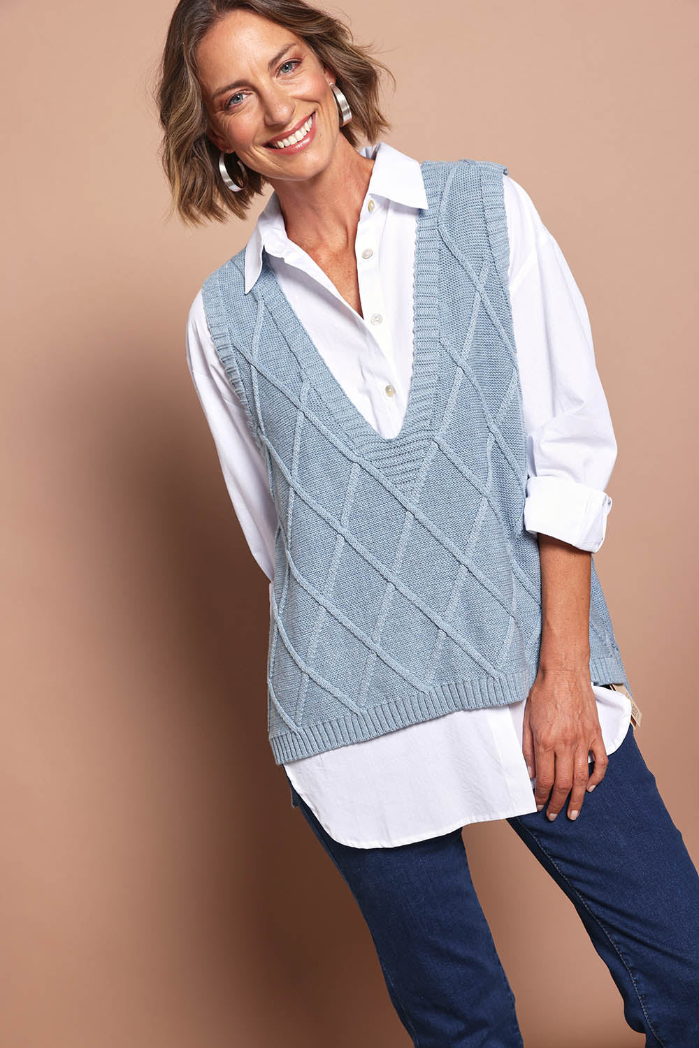 Model Riina wearing size S of the Liora Knit Vest in colour Lake (Blue), from the front, showing the whole outfit