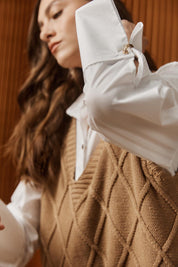 A model wearing the Liora Knit Vest in colour Mocha, from the front, showing the whole outfit