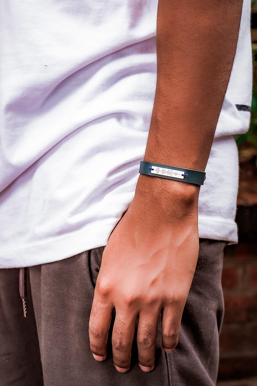 A model wearing the Light Triumphs Over Darkness Thick Vegan Leather Bracelet in colour Blue (Blue), from the front, showing the whole outfit