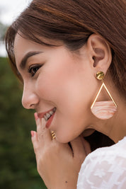 A model wearing the Desert Sand Earrings in colour Gold (Metallics), from the front, showing the whole outfit