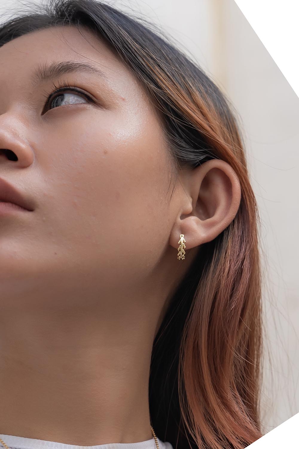 A model wearing the Mustard Seed Hoop Earrings in colour Gold (Metallics), from the front, cropped image
