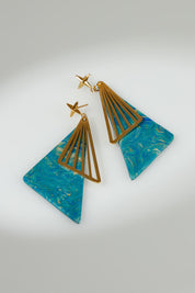 A model wearing the Parting Waters Drop Earring in colour Bluegold (Metallics), from the front, showing the whole outfit