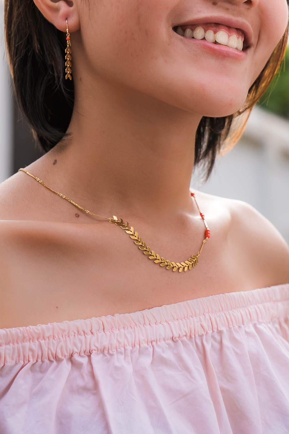 A model wearing the Desert Wildflower Necklace in colour Gold (Metallics), from the front, showing the whole outfit