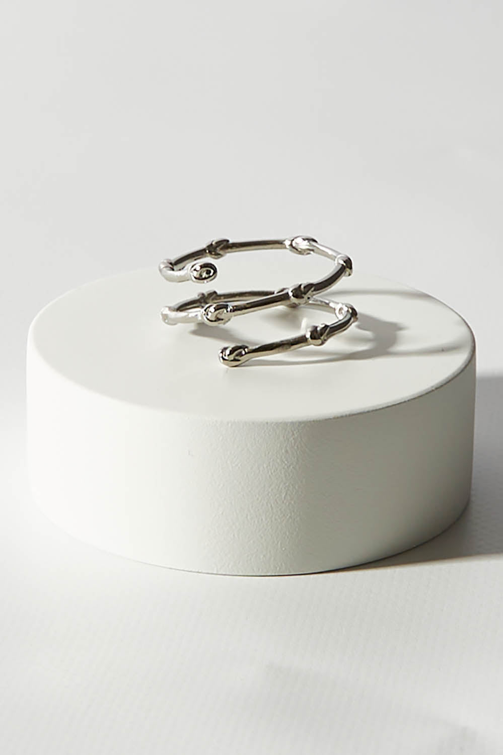 A model wearing size OneSize of the Knots Of Freedom Ring in colour Steel (Metallics), from the front, showing the whole outfit