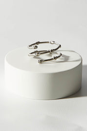 A model wearing size OneSize of the Knots Of Freedom Ring in colour Steel (Metallics), from the front, showing the whole outfit
