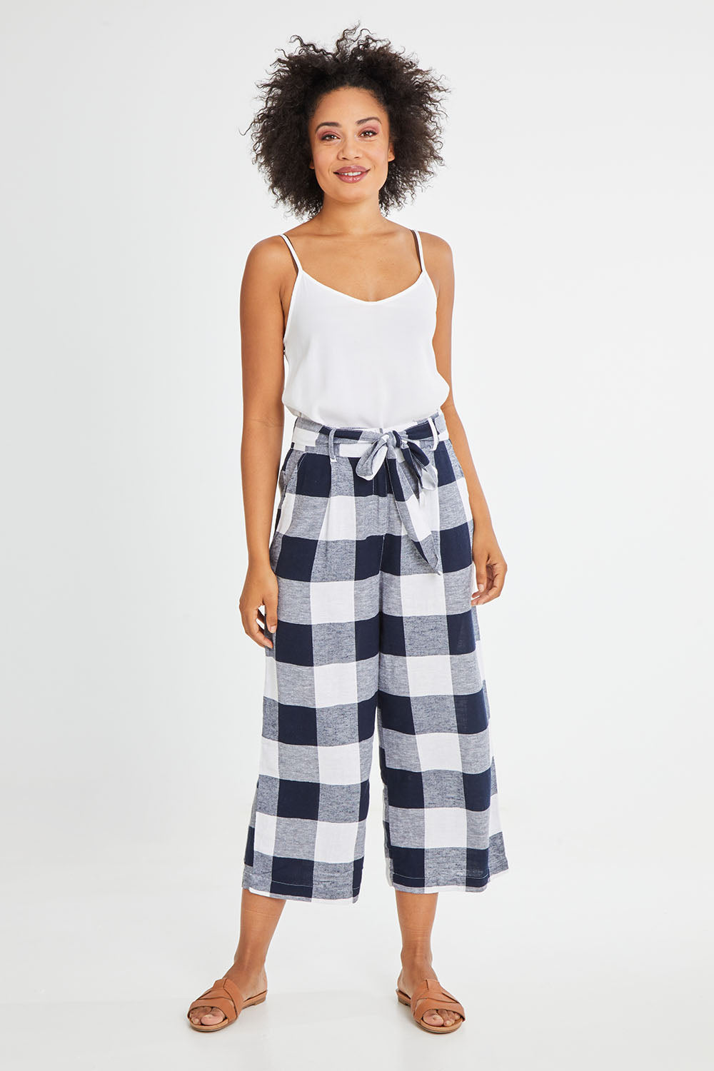 Model Olivia wearing size 10 of the Willow Check Pants in colour Navy (Blue), from the front, showing the whole outfit