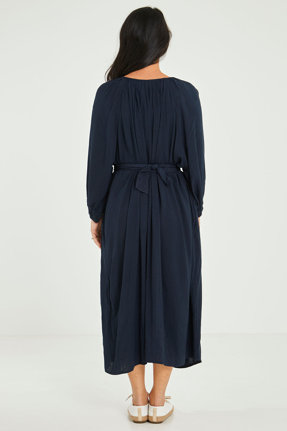 Model Katie wearing size 10 of the Orla Midi Dress in colour Drksapp (Blue), from the back