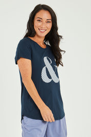 Model Katie wearing size 10 of the Ampersand Tee in colour Drksapp (Blue), from the front, cropped image