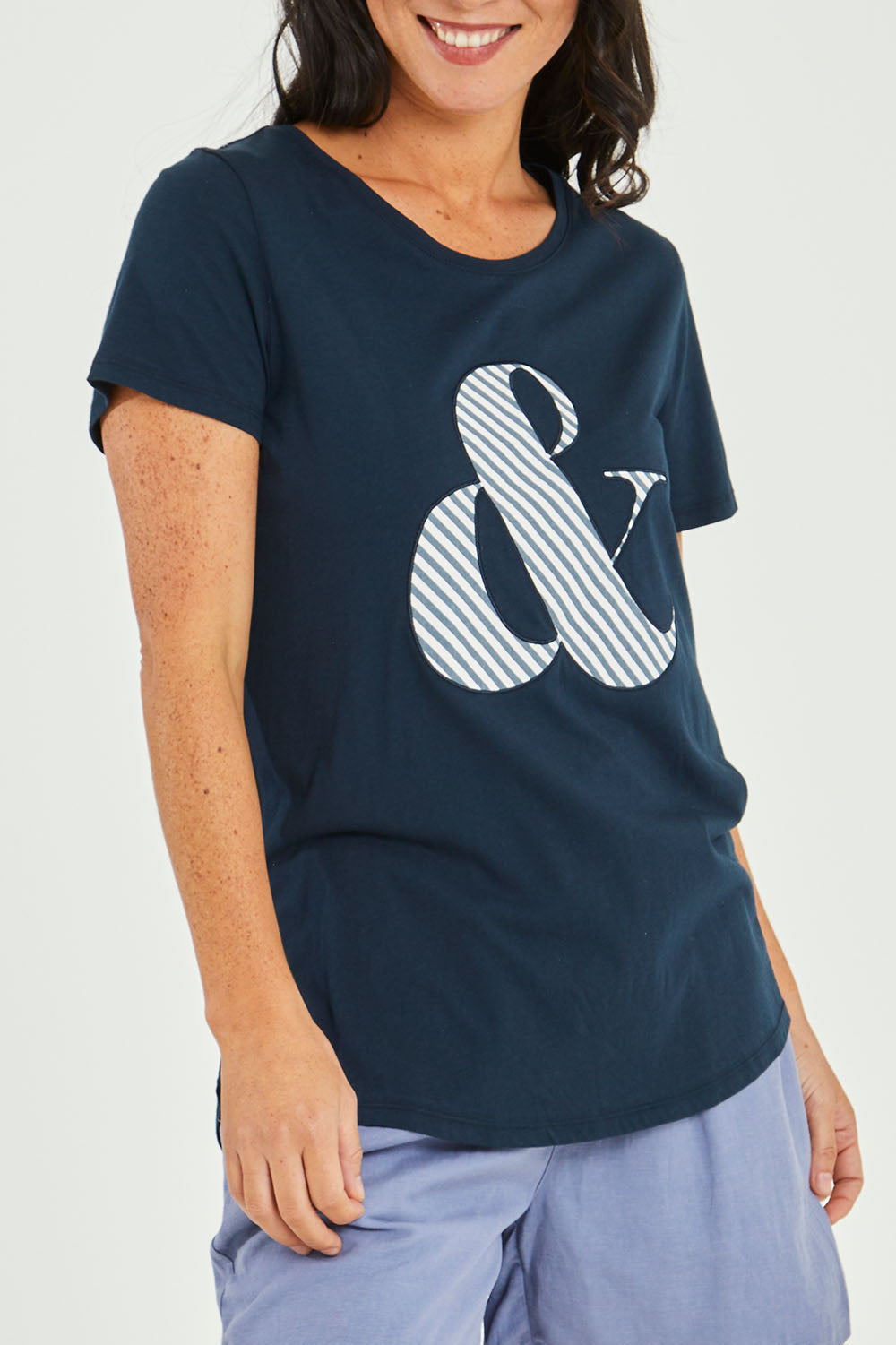 Model Katie wearing size 10 of the Ampersand Tee in colour Drksapp (Blue), from the front, cropped image