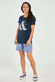 Model Katie wearing size 10 of the Ampersand Tee in colour Drksapp (Blue), from the front, showing the whole outfit