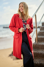 Model Maggie wearing size S of the Tamsin Coat in colour Poppy (Red), from the front, showing the whole outfit