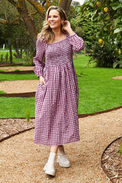 A model wearing the Pippa Check Dress in colour Winecheck (Purple), from the front, showing the whole outfit