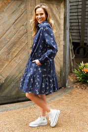 A model wearing the Jolie Floral Shirt Dress in colour Navyfloral (Blue), from the front, showing the whole outfit