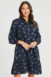 Model Madeline wearing size 10 of the Jolie Floral Shirt Dress in colour Navyfloral (Blue), from the front, cropped image