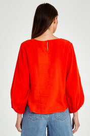 Model Madeline wearing size 10 of the Rosa Top in colour Tangello (Red), from the back