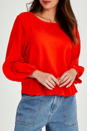 Model Madeline wearing size 10 of the Rosa Top in colour Tangello (Red), from the front, cropped image