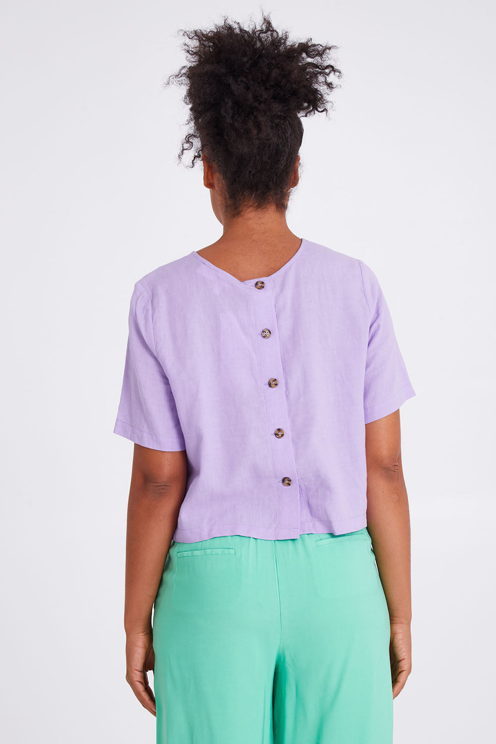 Model Olivia wearing size 10 of the Juniper Top in colour Periwinkle (Purple), from the back
