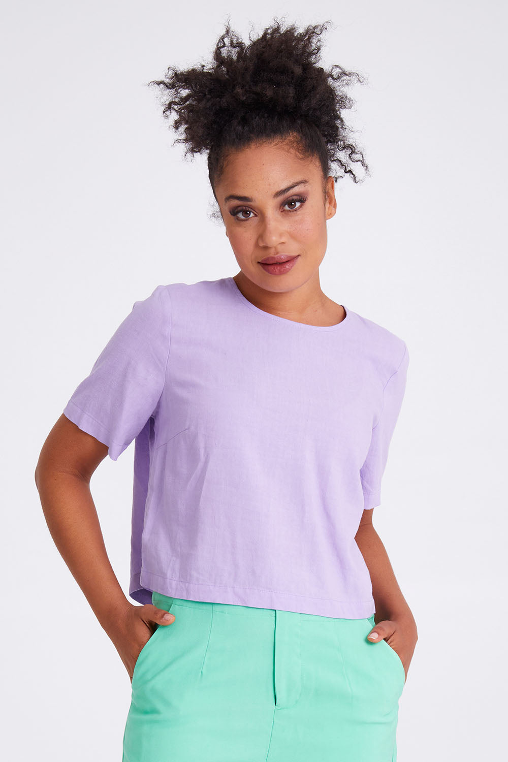 Model Olivia wearing size 10 of the Juniper Top in colour Periwinkle (Purple), from the front, cropped image