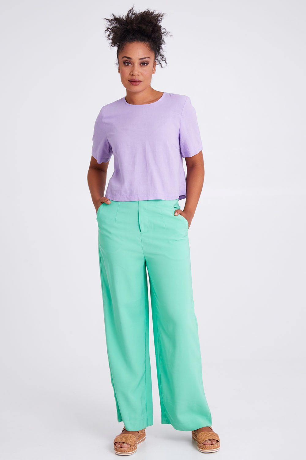 Model Olivia wearing size 10 of the Juniper Top in colour Periwinkle (Purple), from the front, showing the whole outfit