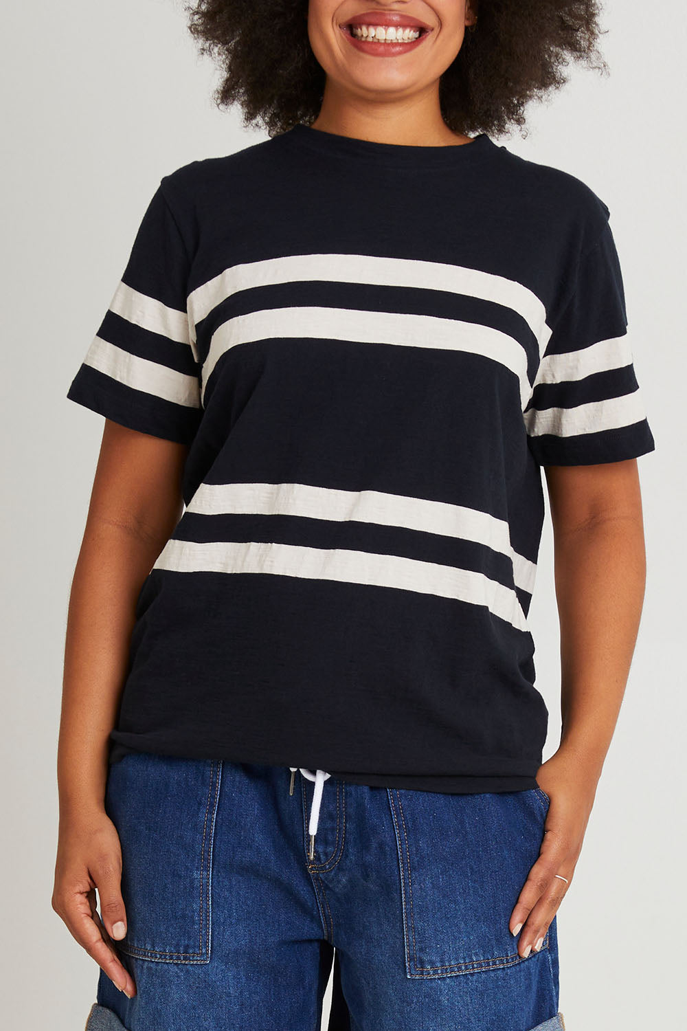 Model Olivia wearing size 10 of the Allegra Ss Tee in colour Navywhite (Blue), from the front, cropped image