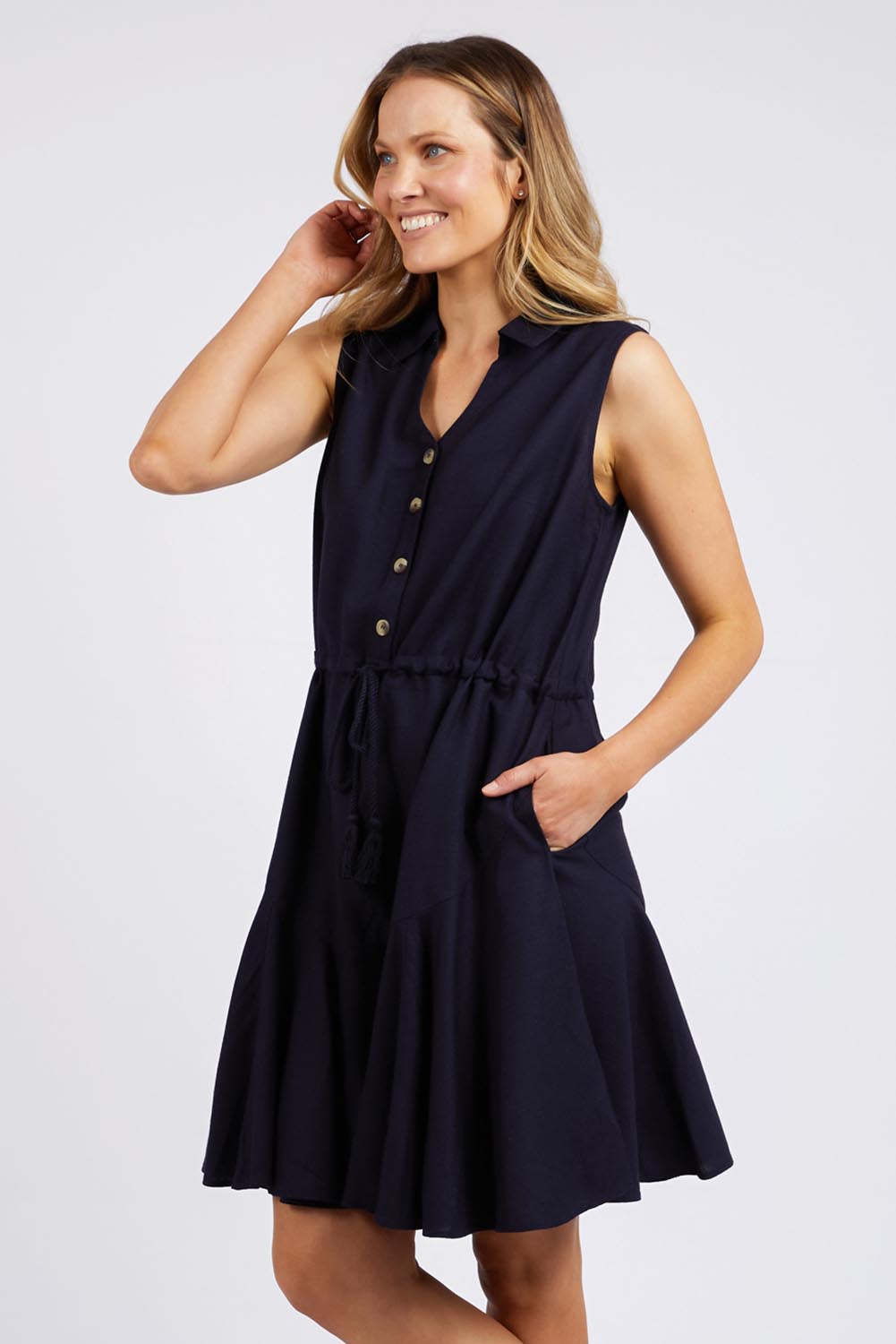 A model wearing the Clem Flippy Dress in colour Navy (Blue), from the front, cropped image
