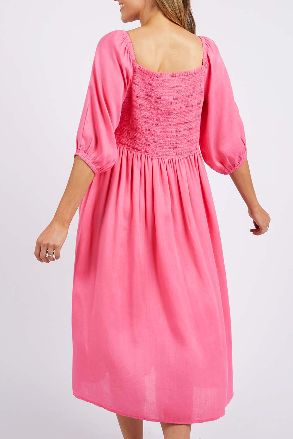 A model wearing the Dusk Midi Dress in colour Pklemonade (Pink), from the back