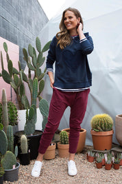A model wearing the Weekend Picnic Pant in colour Burgandy (Purple), from the front, showing the whole outfit