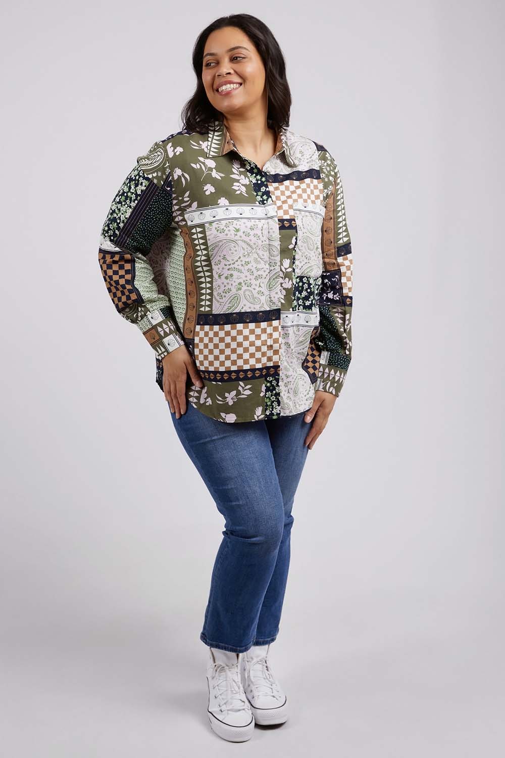 A model wearing the Vetiver Patchwork Shirt in colour Patchwork (Green), from the front, showing the whole outfit
