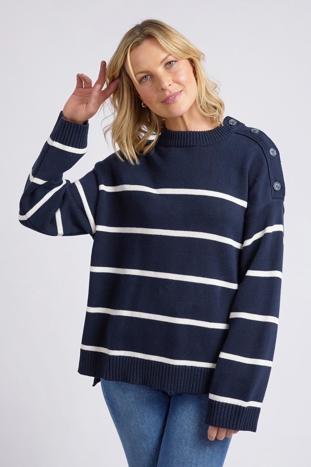 A model wearing the Iris Stripe Knit in colour Navywhite (Blue), from the front, cropped image