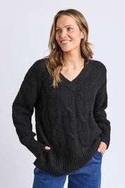 A model wearing the Tallulah Cable Knit in colour Black (Black), from the front, cropped image