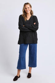 A model wearing the Tallulah Cable Knit in colour Black (Black), from the front, showing the whole outfit